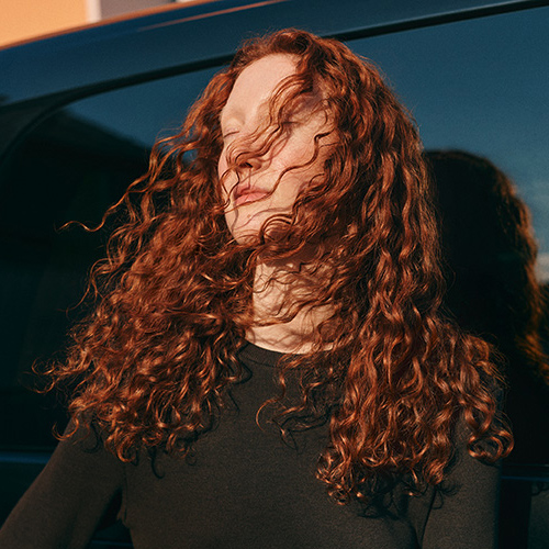 Model mit gelockten roten Haaren